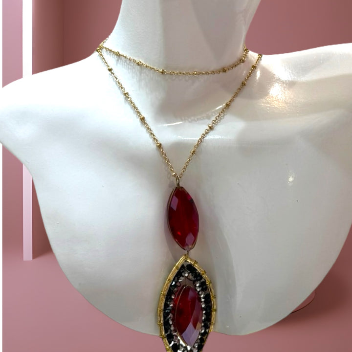 Gold brass chain necklace adorned with red crystals.