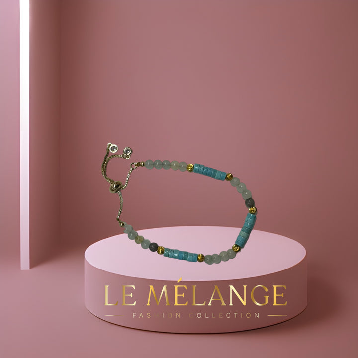 Gold-plated single bangle with an adjustable aquamarine stone and a minimalist design.